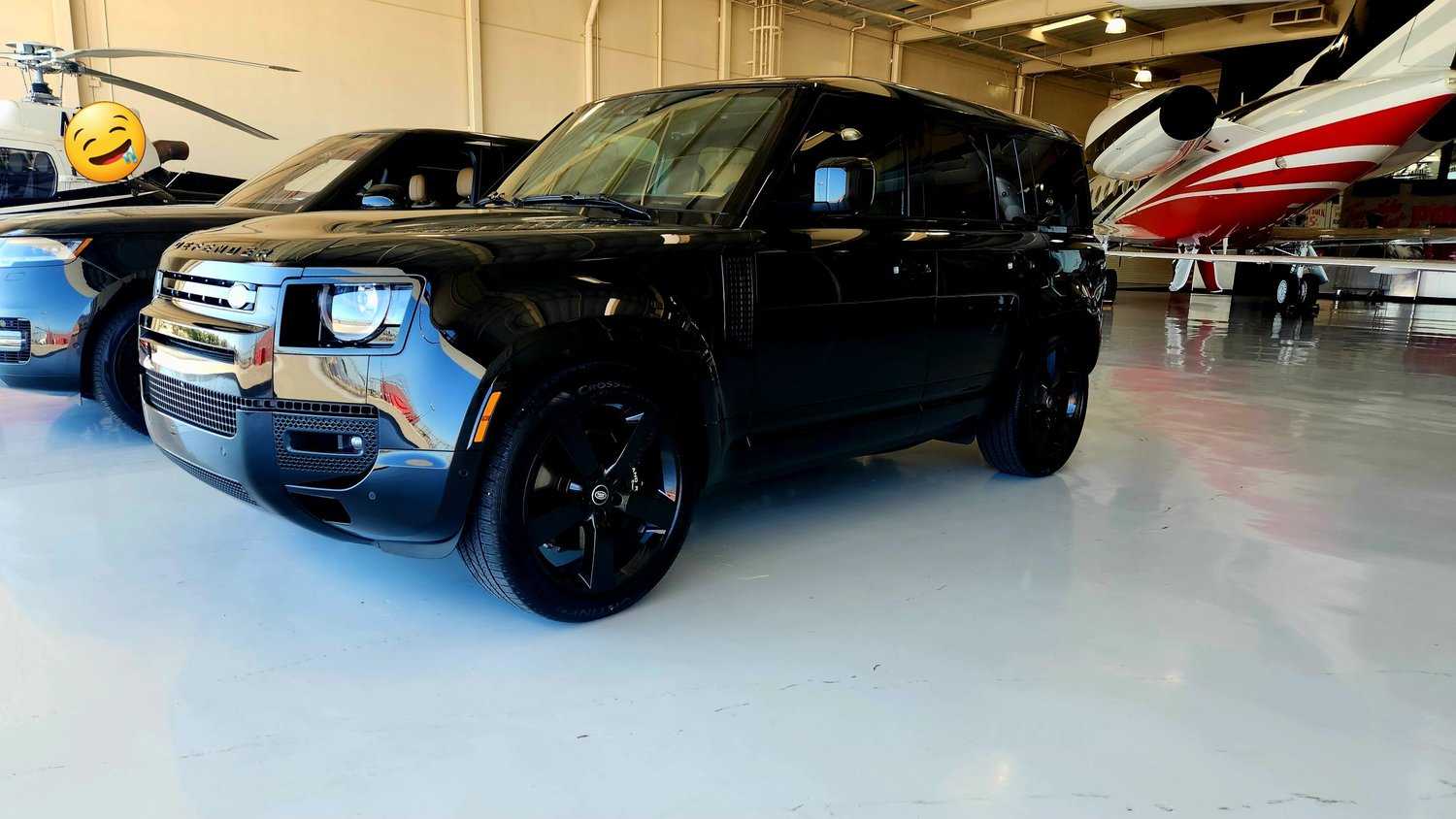 Black Land Rover Defender after a full exterior detail beside a private jet in a Las Vegas hangar.
