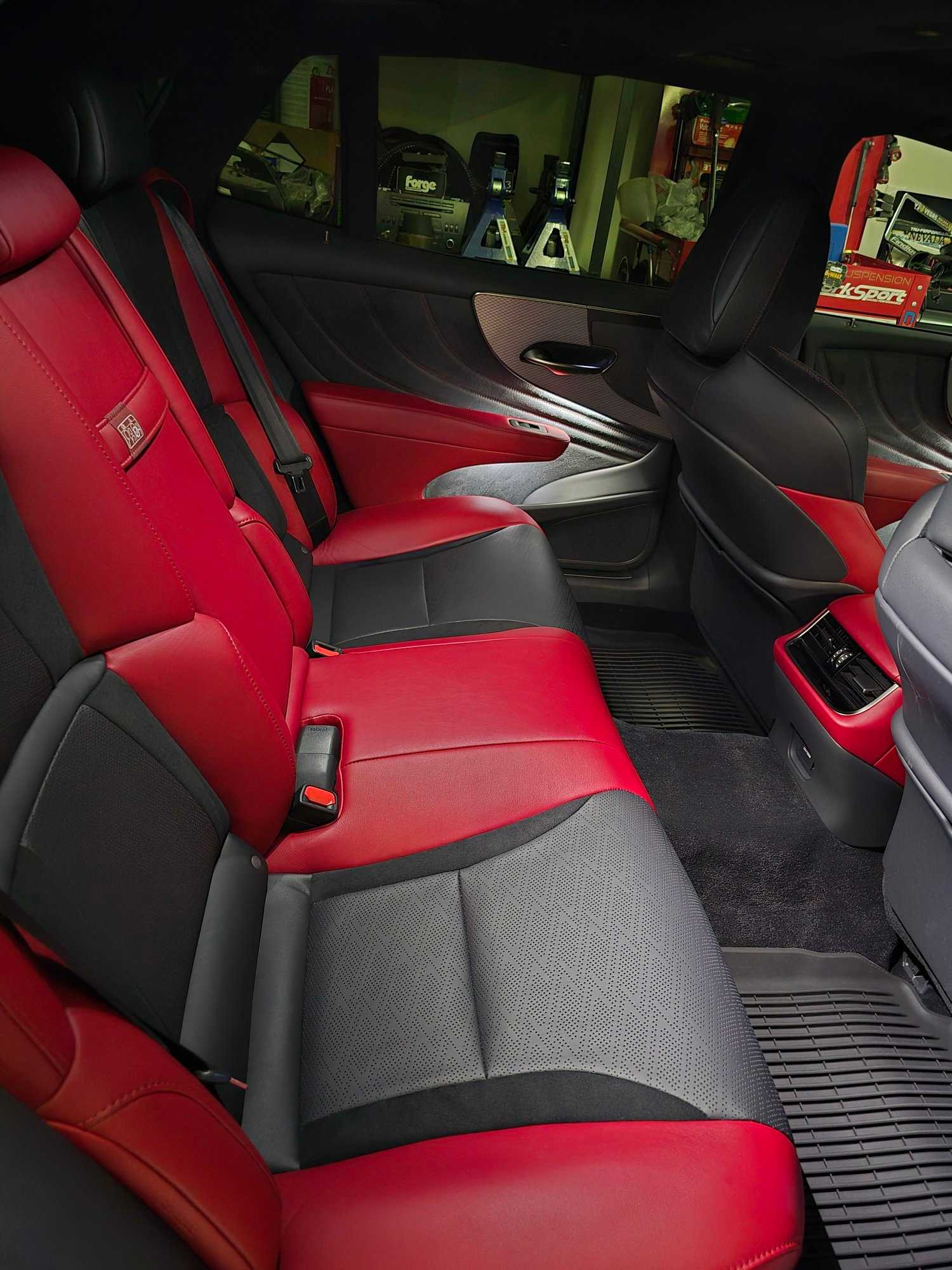 Luxury sedan interior with red and black leather seats after cleaning and conditioning.