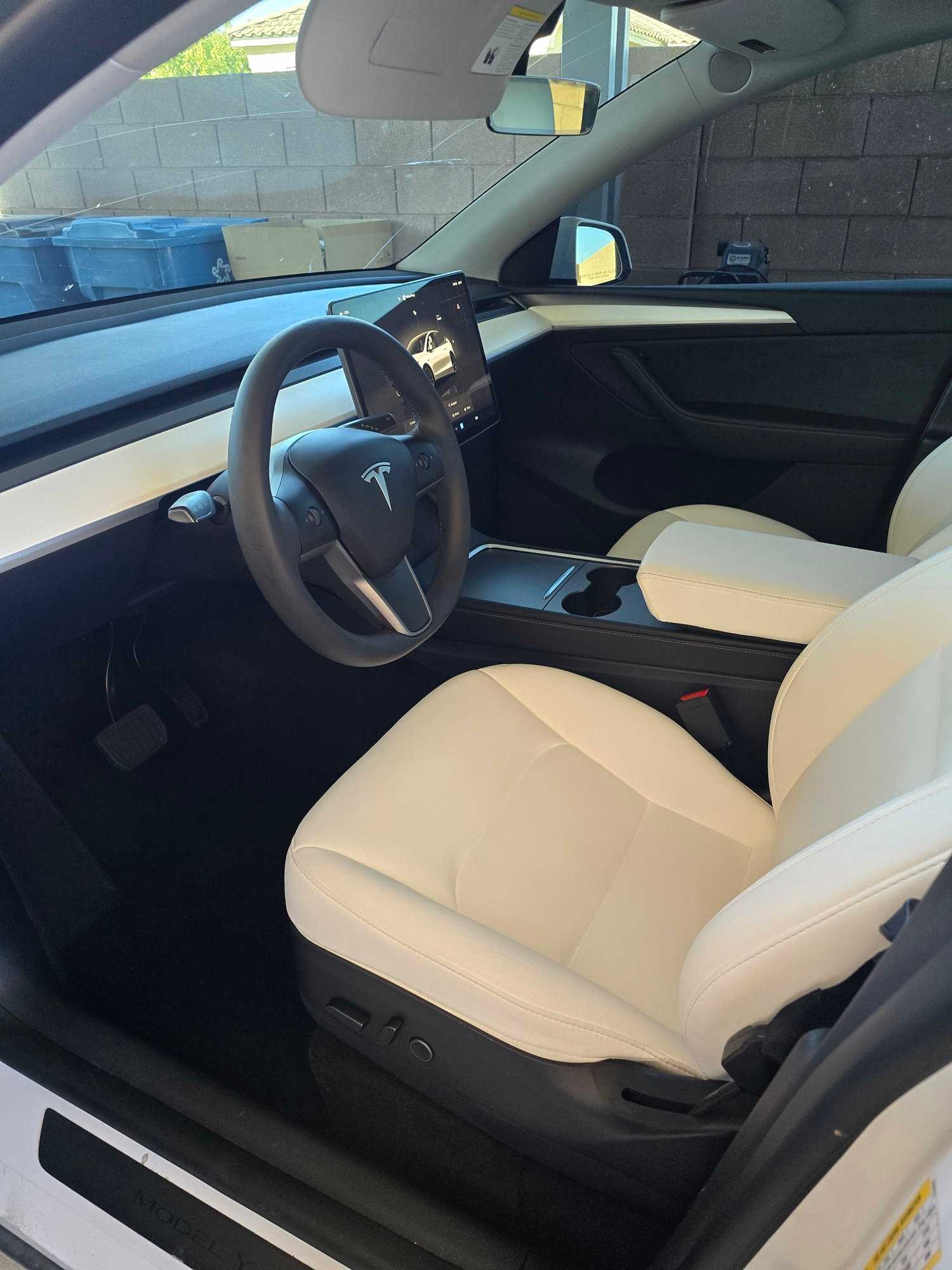 Tesla interior with white seats and central touchscreen after interior detailing.