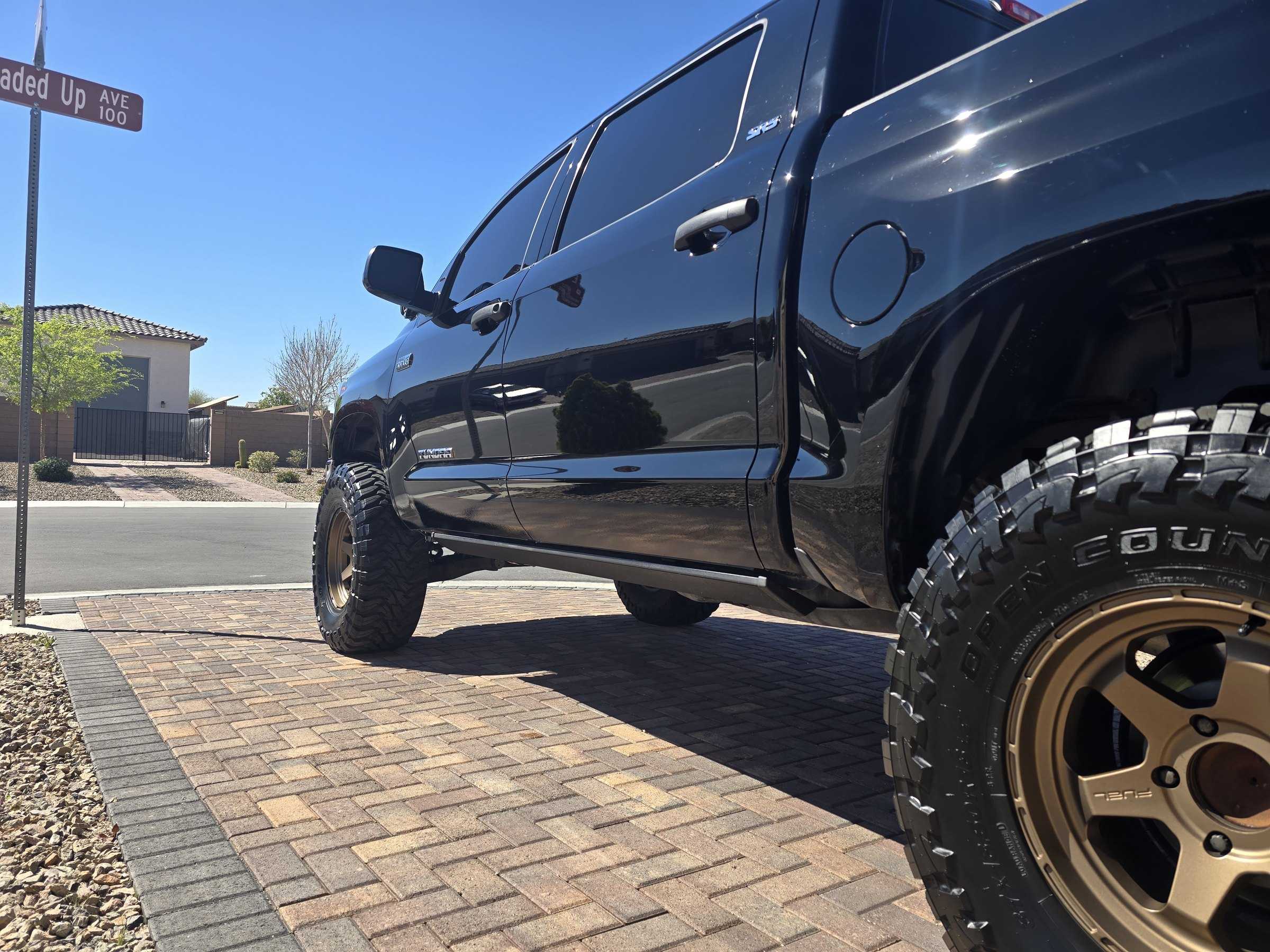 Lifted black Toyota Tundra with a deep gloss finish and bronze wheels after a full exterior detail.