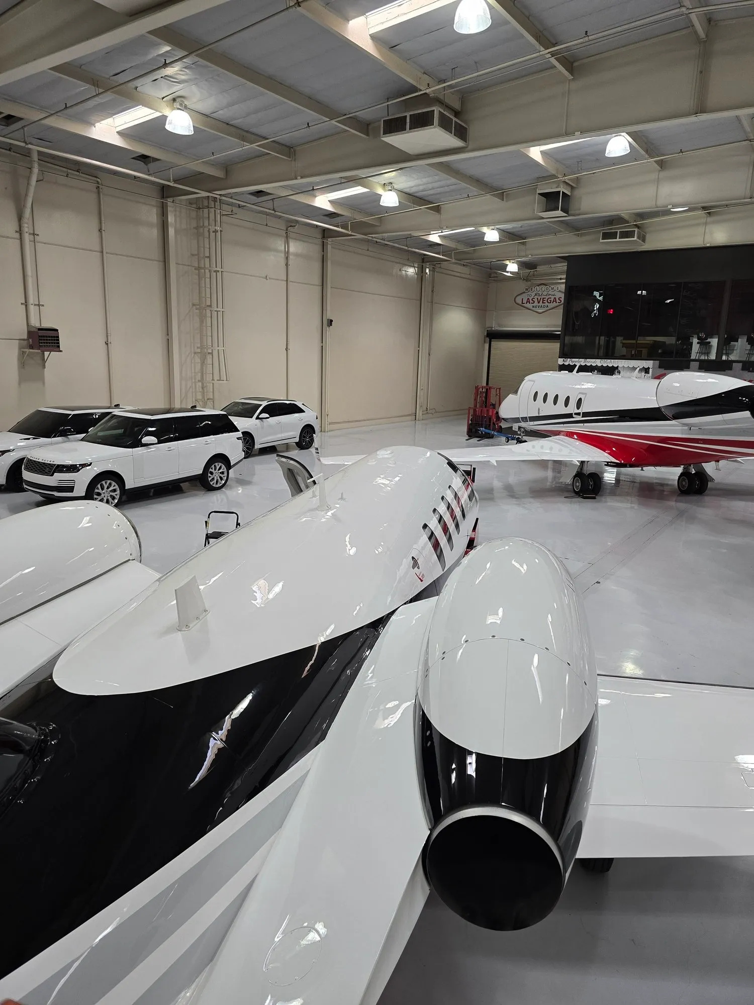 Business jets and a light aircraft parked inside a Las Vegas hangar.