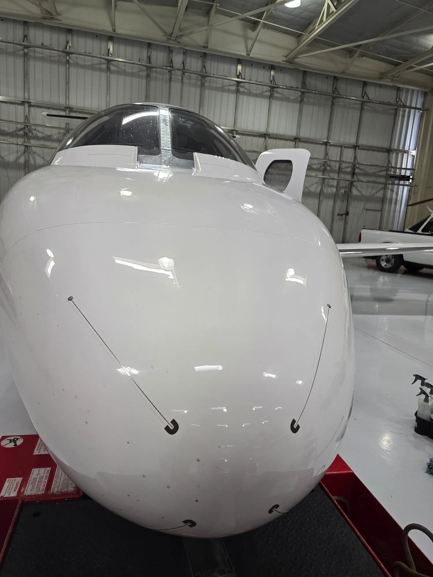Detailed and coated nose of a private jet in the hangar.