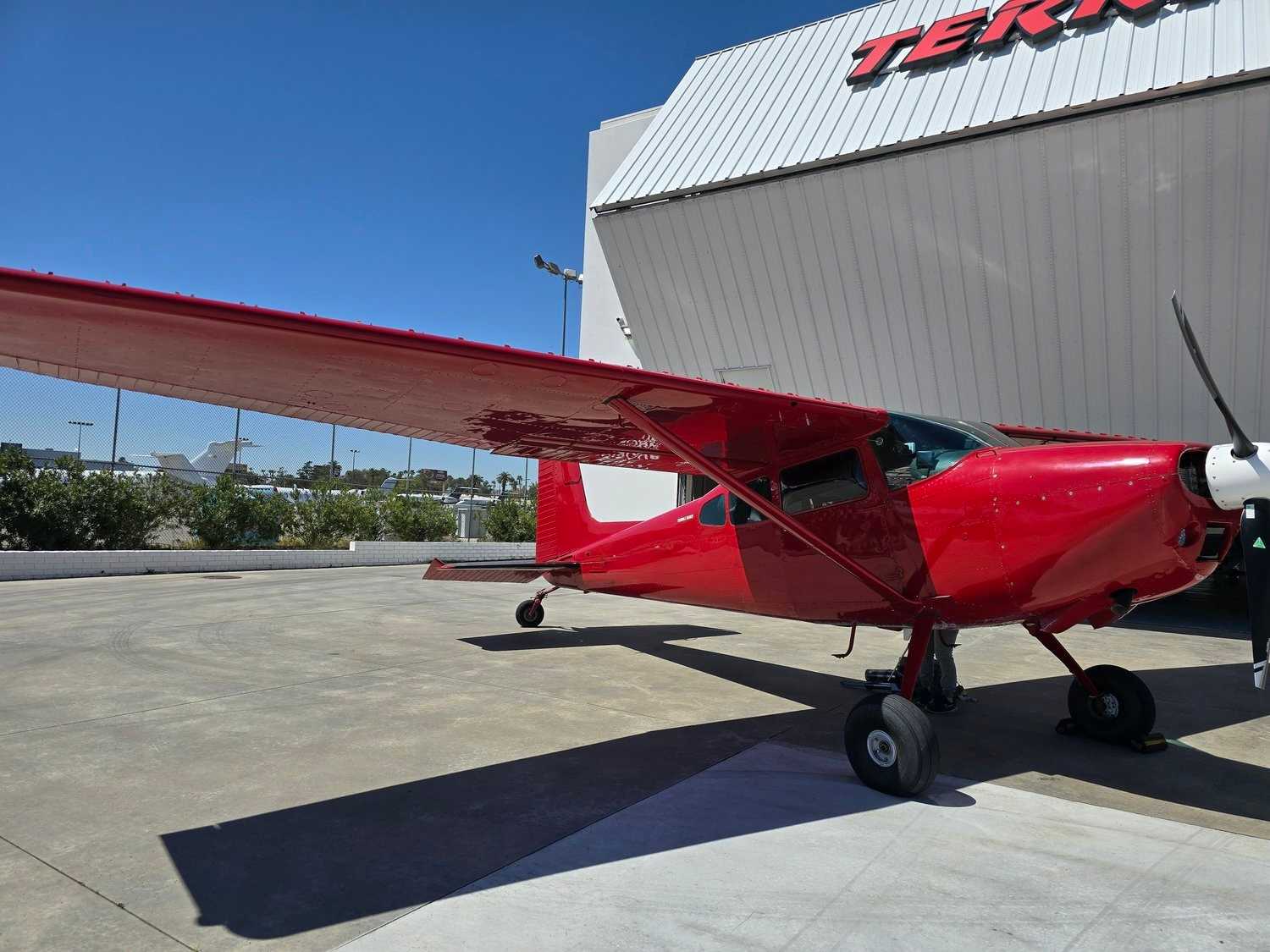 Red Cessna single-engine aircraft parked outside a Las Vegas hangar.