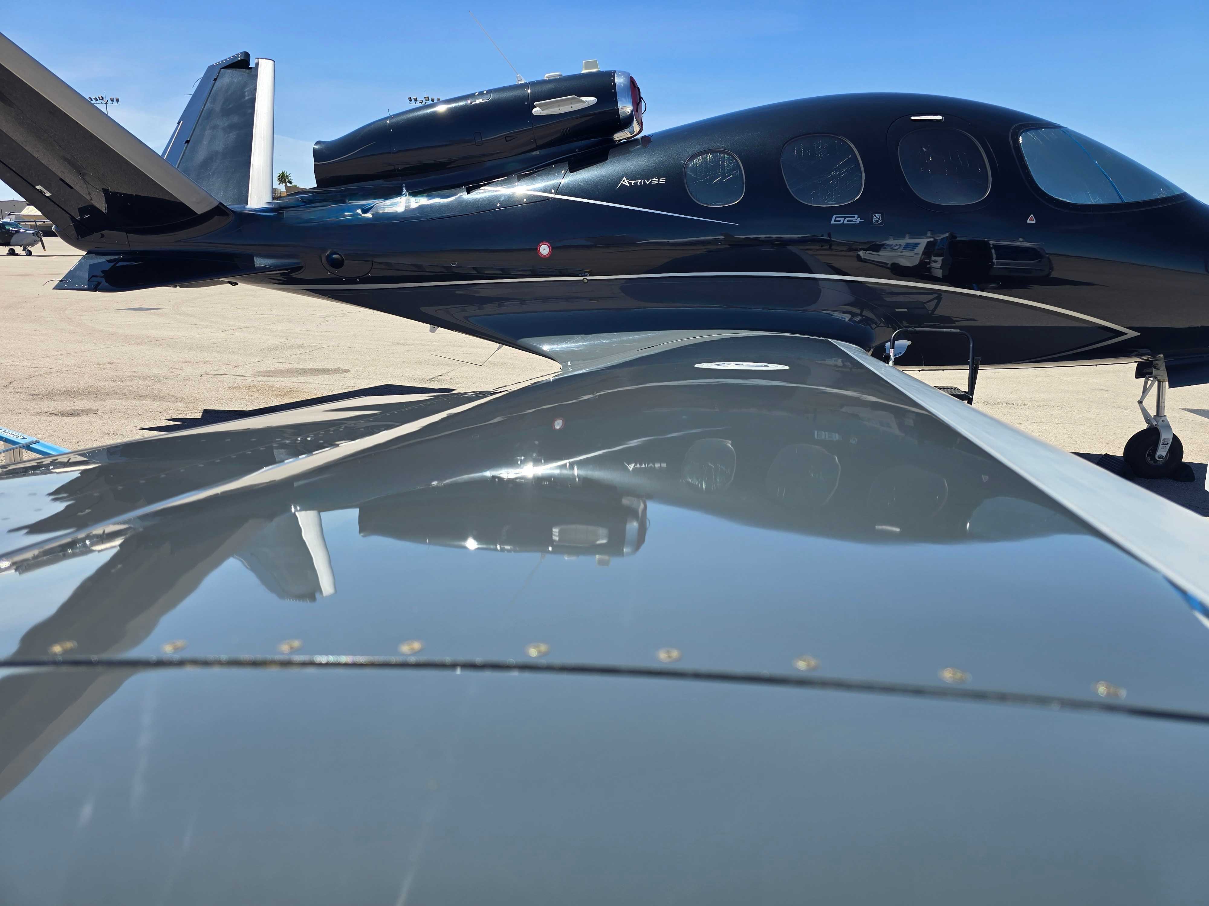 Black Cirrus Vision Jet on the ramp with a freshly cleaned, glossy wing in the foreground after a trip clean.